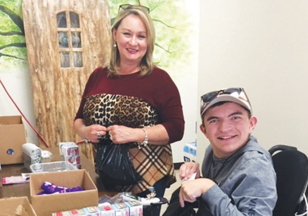 Submitted photo   Community Care Clinic volunteers Lisa Black and her son, Nicholas, pack personal care bags that will be sent to other nonprofits as part of the 49 Days of Gratitude.