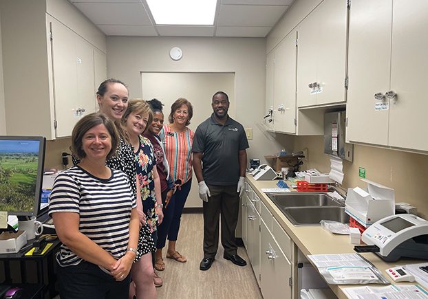 Amy Wilson, Caroline Parrott, Cathy Teat, DeAnna Turner, Krista Woolly, and a training representative stand next to the testing machine and supplies provided through the grant. Photo submitted.